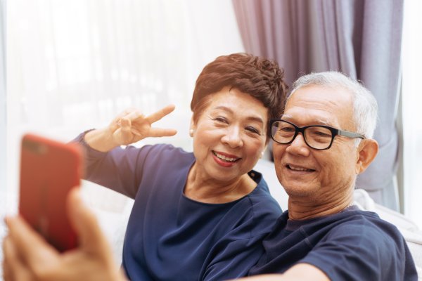 Happy Asian tourists taking a selfie in their hotel room