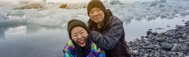 Older Chinese tourist couple posing for a photo in Iceland